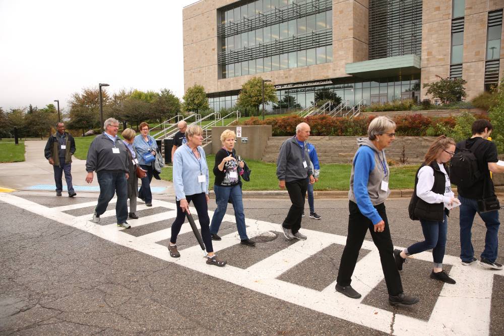 Class of '68 crossing the road during the campus tour.